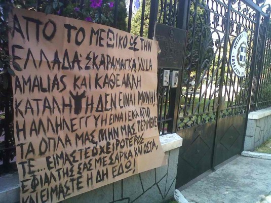 Sullo striscione si legge: "Dal Messico alla Grecia: Skaramaga, Villa Amalias e ogni altra occupazione non siano sole! La solidarietà è una delle nostre armi. Non ci aspettate…siamo il vostro incubo peggiore, in carne e ossa, e siamo già qui!"